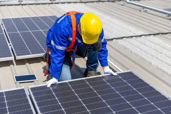 Teknisyenler, bir sanayi fabrikasının çatısına güneş paneli standartları kurup denetliyorlar. Doğadan elde edilen elektrik enerjisi güneş ışığı temiz yenilenebilir enerji.