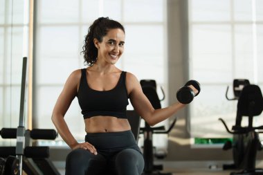 Halterli güçlü Latin kadın spor salonunda ağırlık kaldırıyor. Spor antrenmanları ağırlık azaltma egzersizleri, kilo verme egzersizleri, sağlık hizmetleri..