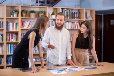İş adamları masa başı pazarlama stratejisi analizi için beyin fırtınası yapıyor. Organizasyondaki etkili insanlar, şirkette çalışmak için fikir kullanıyorlar..