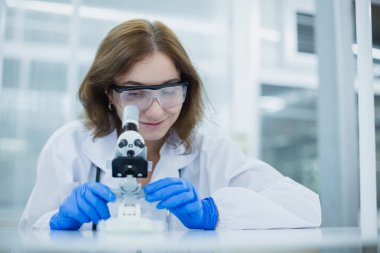 Bilim bölümü öğrencileri mikroskop araştırması için tıp bilimine bakıyorlar. Bilimsel kimya biyolojisini öğrenmek için tıbbi verileri analiz et. Laboratuvarda kadın bilim adamı.