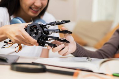 El robotu modelini kapatın. Robotla insan tokalaşması. Sınıfta kız öğrencilerin eğitimi.