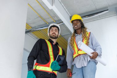 İnşaat mühendisi ve kadın Afro-Amerikan inşaat alanında çalışma kalitesi. Altyapı inşaatında çalışan çeşitli uluslardan oluşan bir ekip..