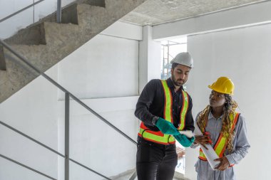 İnşaat mühendisi ve Afro-Amerikan kadın inşaat alanında tablet kontrol kalitesi kullanan inşaat mühendisi. Altyapı inşaatında çalışan çeşitli uluslardan oluşan bir ekip..