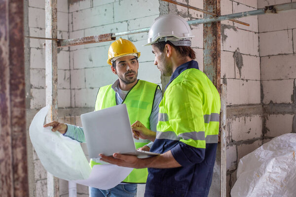 человек инженер-строитель дома строительства холдинг чертеж чертежа. мужчина-архитектор, стоящий на строительстве дома. мастер на рабочем месте.