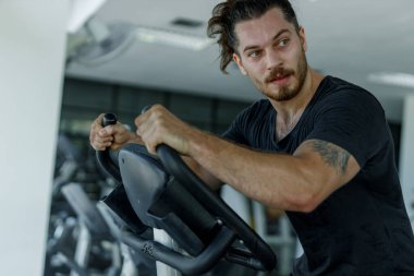 Erkek, egzersiz yaptıktan sonra yorgun ve terli bir yüz ifadesine bürünür. Sporcu kas zayıflığı motivasyonu fitness kalorileri yakar sağlık için kilo verir. Spor salonunda koşu bandı egzersizi..