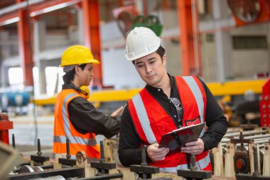 Ekip mühendisleri metal levha fabrikasında üretilen demir ürünlerini kontrol ediyor. Metalwork Ekibi 'nin erkek yöneticisi Panoya yazma kalitesini kontrol etmek için profesyonel iş.