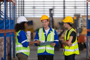 Depo çalışanı ara verip lojistikte sohbet ediyor. Fabrika sanayi müfettişi imalatı. Depo çalışanı konuşma planı depoda inceleniyor..