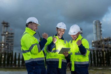 Profesyonel elektrik mühendisi üniformasının başarısı birlikte çalışırken tablet güç santrali ya da istasyonun petrokimyasal gece saatlerini rafine ettiğini gösteriyor..