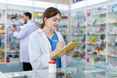 Eczanedeki ürünlerin bilgi çeşitleri için uyuşturucu satıcısı ilaç kontrolü. Kadın eczacılar, eczanede çalışan panolara rekor satışlar yapıyorlar..