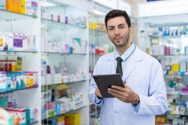 Erkek eczacılar, eczanedeki tablet aracılığıyla hastalar için internetten ilaç seçiyorlar. Uyuşturucu satıcısı hastaya göndermeden önce bilgi için tablet kullan.