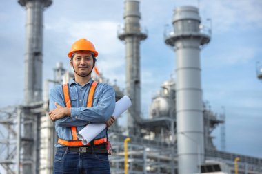 Asya işçi santralinin portresi. Kolları çaprazlanmış. Güvenlik üniforması kaskı takan bir mühendis. Adam elektrik jeneratörü onarım operasyonları. İşçi petrokimyasal enerji.