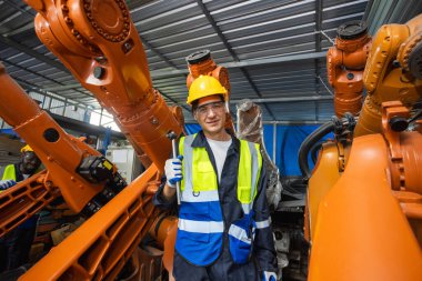 Erkek teknisyen, endüstriyel modern fabrikada otomasyon robotik kolunu kontrol ediyor. Fabrika yenileme otomasyon robotunda çalışan adam..