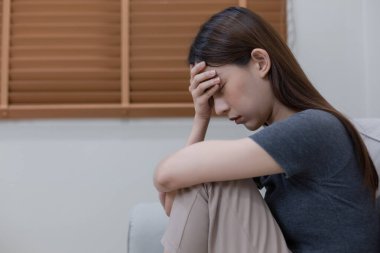 Yatak odasında yalnız başına depresyonda olan bir kadın. Kadın baş ağrısı, mutsuz duygu. Kanepede tek başına oturmak. Zihinsel sağlık sorunları umutsuzluğa kapıldı.