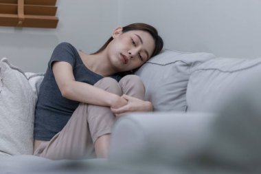 Yatak odasında yalnız başına depresyonda olan bir kadın. Kadın baş ağrısı, mutsuz duygu. Kanepede tek başına oturmak. Zihinsel sağlık sorunları umutsuzluğa kapıldı.