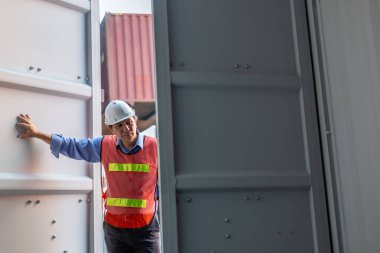 Foreman üniforma giyiyor ve lojistik lojistik kapı konteynırı kargosunu açıyor, konteynırları kontrol ediyor lojistik ithalat ve nakliye alanlarını dolduruyor..