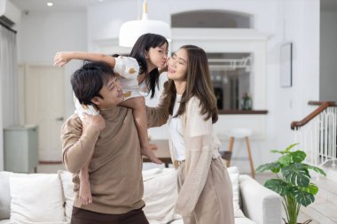 Asyalı mutlu aile babası, tatlı kızı olan anne evde eğlenen kız, babasının arkasında oturan kız. ilişki ailesi. 