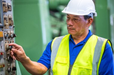 Ağır endüstri mühendisi profesyonel işçi endüstride güvenlik üniforması giyiyor. Erkek yönetici sistem inşaatını kontrol ediyor.