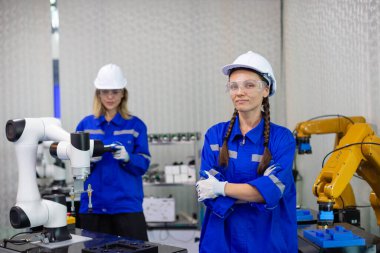 Endüstriyel laboratuvar fabrikasında portre teknisyeni otomasyon robotları. Kadın ekip teknolojik araştırma ve geliştirme fabrika yenilikçi otomasyon robotunda çalışıyor.