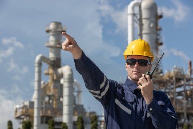 Profesyonel mühendis güvenlik üniforması ve petrol petrokimya fabrikası rafine eden tankın yakınındaki çalışma alanı giyiyor. Sanayi fabrikası enerji santrali.