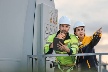 Ekip mühendisi rüzgar türbini işçi üniforması güvenlik anketi operasyon planlama yel değirmeni temiz enerjisini tartışıyor. Alternatif teknoloji çevreyi korur küresel ısınma sorunlarını azaltır.