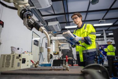 Endüstriyel laboratuvar fabrikasında uzaktan kumandalı otomasyon robotları kullanan teknisyen mühendisi. Erkek takım teknolojik araştırma ve geliştirme fabrika yenilikçi otomasyon robotunda çalışıyor.