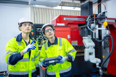 Endüstriyel laboratuvar fabrikasında uzaktan kumandalı otomasyon robotları kullanan teknisyen mühendisi. Ekip teknolojik araştırma ve geliştirme fabrika yenileme otomasyon robotunda çalışıyor..