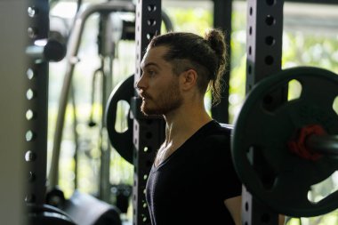 Kaslı adam egzersiz yapıyor ve ağırlık kaldırıyor. Kol ve omuz kaslarını güçlendir. Ağırlık kaldırma egzersizi..