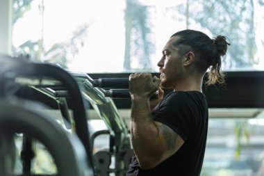 Spor salonundaki kalorili pres makinesinde çalışan adam sağlık için kilo kaybediyor. Spor salonunda göğüs pres makinesi çalıştıran güçlü bir sporcu. Kol ve omuz kaslarını geliştirmek için egzersiz..