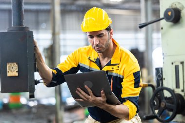 Endüstriyel mühendis üniforma ve kask giyer dizüstü bilgisayar kullanır fabrikada sistem makinesini kontrol ederler. Teknik direktör imalatı. İşçi sanayi fabrikası.
