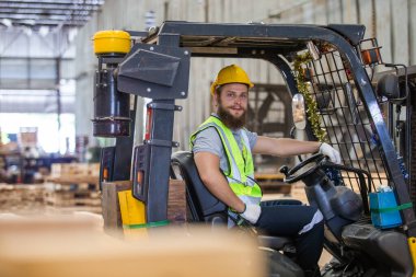 Odun endüstrisi işçisi forklift kullanıyor. Depo kontrplak ithalat ihracat kargosu. Erkek marangoz işçi ahşap depolama endüstrisi.