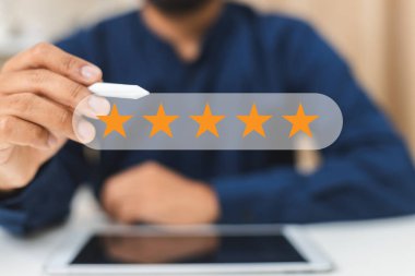 Yıldız tatmini anketi, iş adamı parmaklarından tablete beş yıldızlı ikonlar, iş sıralaması. Geri bildirim, değerlendirme, anket, pozitif.