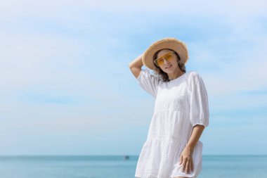 Güzel, kendine güvenen, çekici, çekici, sarı saçlı bir kadın. Kenarlı bir şapka takıyor ve tropikal sahilde eğleniyor. Portre kadın rahatlaması tatilin tadını çıkarıyor. Moda hanımefendisi yaz yaşam tarzı.