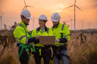 Dizüstü bilgisayarı tutan güvenlik üniforması giyen takım mühendisi akşam güneş battığında enerji santralinde yenilenebilir enerji planlarını tartıştı. Teknoloji ortamı küresel ısınma sorunlarını azaltıyor.