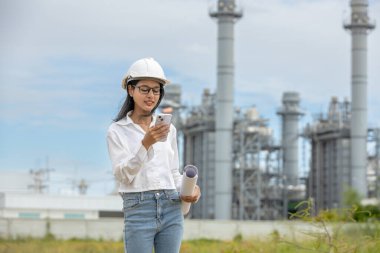 Mühendis, elektrik enerjisi üreten planlı çalışan bir fabrikada akıllı telefon kullanıyor. Petrokimya 'da inşaat müdürü petrol rafinerisi. Geliştirme müfettişi Endüstriyel enerji santrali