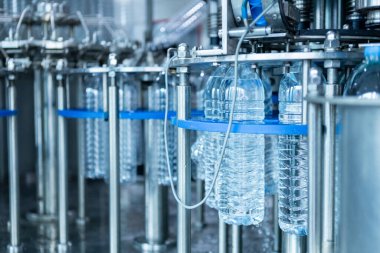Su bitkisi iç. Fabrikadaki su şişeleri üretim hattının robotu. Suyun plastik şişelere doldurulup tüketicilere sunulması süreci.