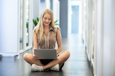 Kütüphanede kitaplığı olan yerde dizüstü bilgisayar kullanan genç.. 