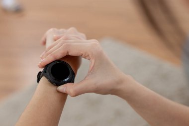 Siyah ekranlı akıllı saat ekranına dokunan kişi. Metin elektroniği, mesaj bildirimleri, egzersiz sırasında kalp atış hızı ölçümleri için akıllı kol saati kullanımının siyah alanı.
