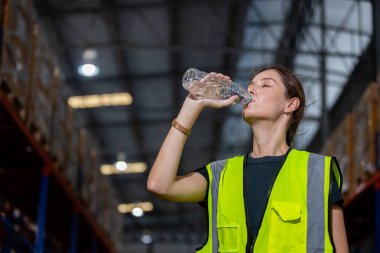 Tatilde fabrikada çalıştıktan sonra plastik şişeden su içen kadınlar. Saf su içmek vücudu tazeler. Reklam için kadın içme suyu..