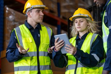 Depo çalışanı ara verip lojistikte sohbet ediyor. Fabrika sanayi müfettişi imalatı. Depo çalışanı konuşma planı depoda inceleniyor..