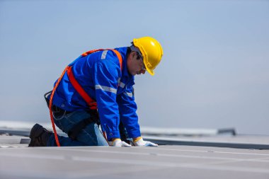 Teknisyenler, bir sanayi fabrikasının çatısına güneş paneli standartları kurup denetliyorlar. Doğadan elde edilen elektrik enerjisi güneş ışığı temiz yenilenebilir enerji.