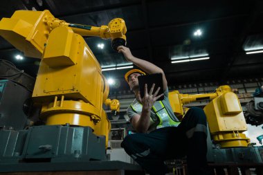 Otomatik mühendis, otomasyon robot silah makinesinin kalite kontrol tabletini kullanarak otomatikman tamirci. Fabrika endüstrisinde üretim yapan servis programlama robotları.