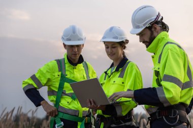 Güvenlik üniforması giyen mühendis, istasyon enerji rüzgar türbinindeki yenilenebilir enerji planlarını tartıştı. teknoloji çevreyi korur küresel ısınma sorunlarını azaltır.