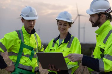 Güvenlik üniforması giyen mühendis, istasyon enerji rüzgar türbinindeki yenilenebilir enerji planlarını tartıştı. teknoloji çevreyi korur küresel ısınma sorunlarını azaltır.