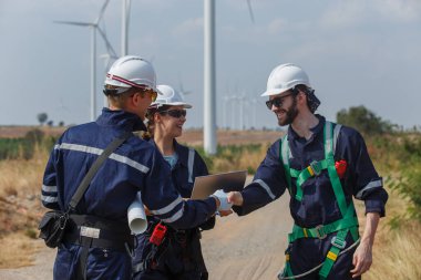 Başarılı bir ekip çalışması mühendisi rüzgar türbini işçi güvenlik üniforması operasyon amaçlı yel değirmeni planlama temiz enerji. Alternatif teknoloji çevreyi korur küresel ısınma sorunlarını azaltır.