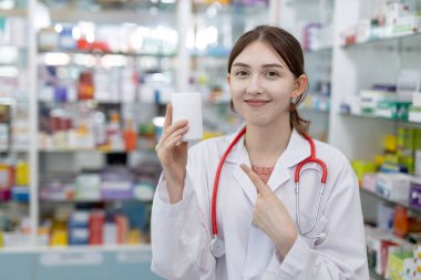 Kadın eczacılar eczanede şişe ve su toplayan haplar bulunduruyorlar. Hastaya göndermeden önce ilaç satıcısının elinde bilgi kontrolü var.