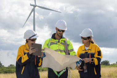 Güvenlik üniforması giyen mühendis, istasyon enerji rüzgar türbininde yenilenebilir enerji hakkında planlarını tartıştı. teknoloji çevreyi korur küresel ısınma sorunlarını azaltır.