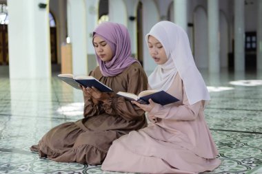 Camide Kur 'an okuyan tesettürlü güzel Müslüman kadınlar. İslami kadın tanrıya dua. Ramazan ve bayram fastikal kavramı.