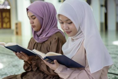 Camide Kur 'an okuyan tesettürlü güzel Müslüman kadınlar. İslami kadın tanrıya dua. Ramazan ve bayram fastikal kavramı.