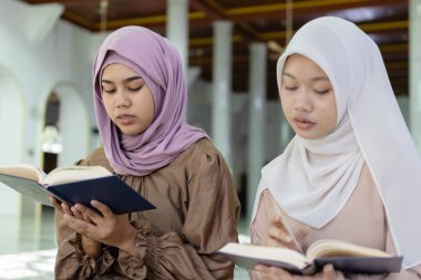 Camide Kur 'an okuyan tesettürlü güzel Müslüman kadınlar. İslami kadın tanrıya dua. Ramazan ve bayram fastikal kavramı.