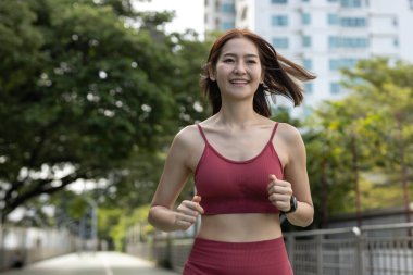 Genç ve güzel kadın spor kıyafetleri sabah koşusundan önce sokak parkını çalıştırıyor. Asyalı güçlü bayan spor kıyafetleri dışarıda koşuyor. fitness sağlıklı konsept.